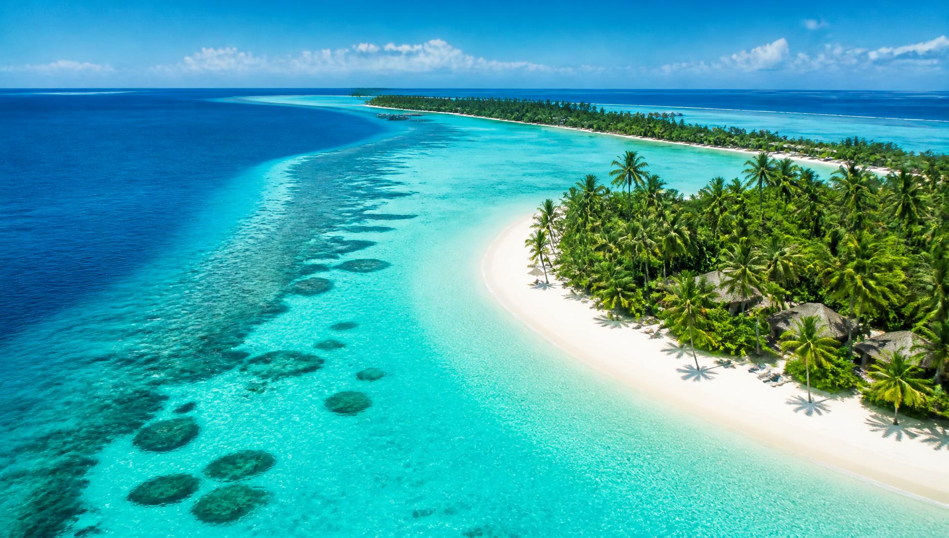 Turquoise Maldives lagoon with a white sand beach and palm trees
